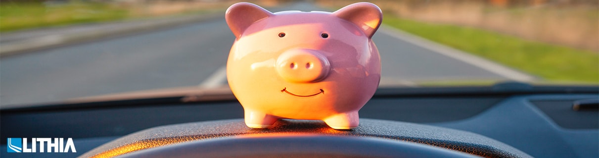 Piggy bank on top of a car dashboard