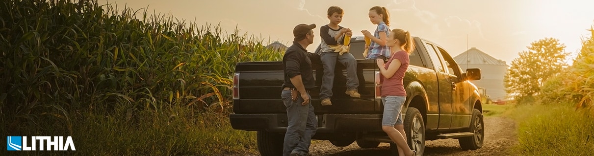 Family in back of a truck at a farm