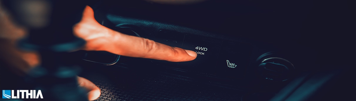 Man pushing a AWD button in a vehicle