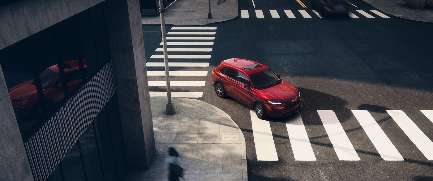 red Honda HR-V SUV turning a city corner