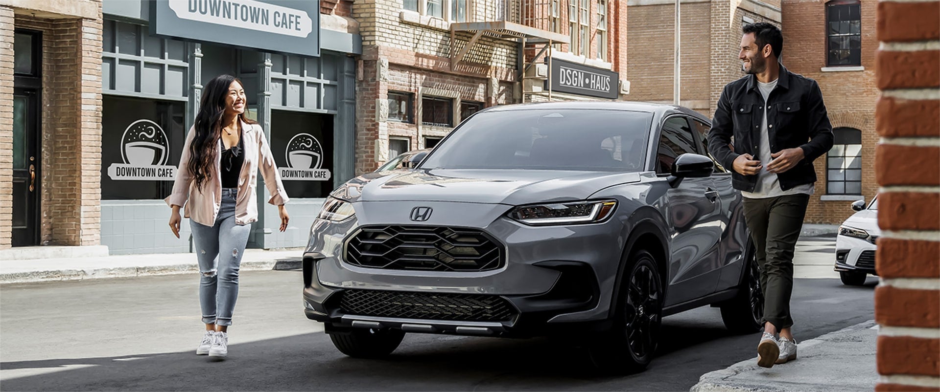 silver Honda HR-V SUV parked in a city with the driver and passenger walking by