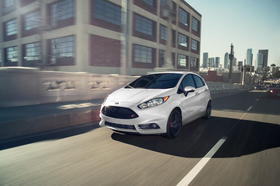 white Ford Fiesta driving fast down the highway