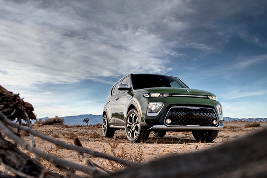 green Kia Soul parked in a rocky desert area
