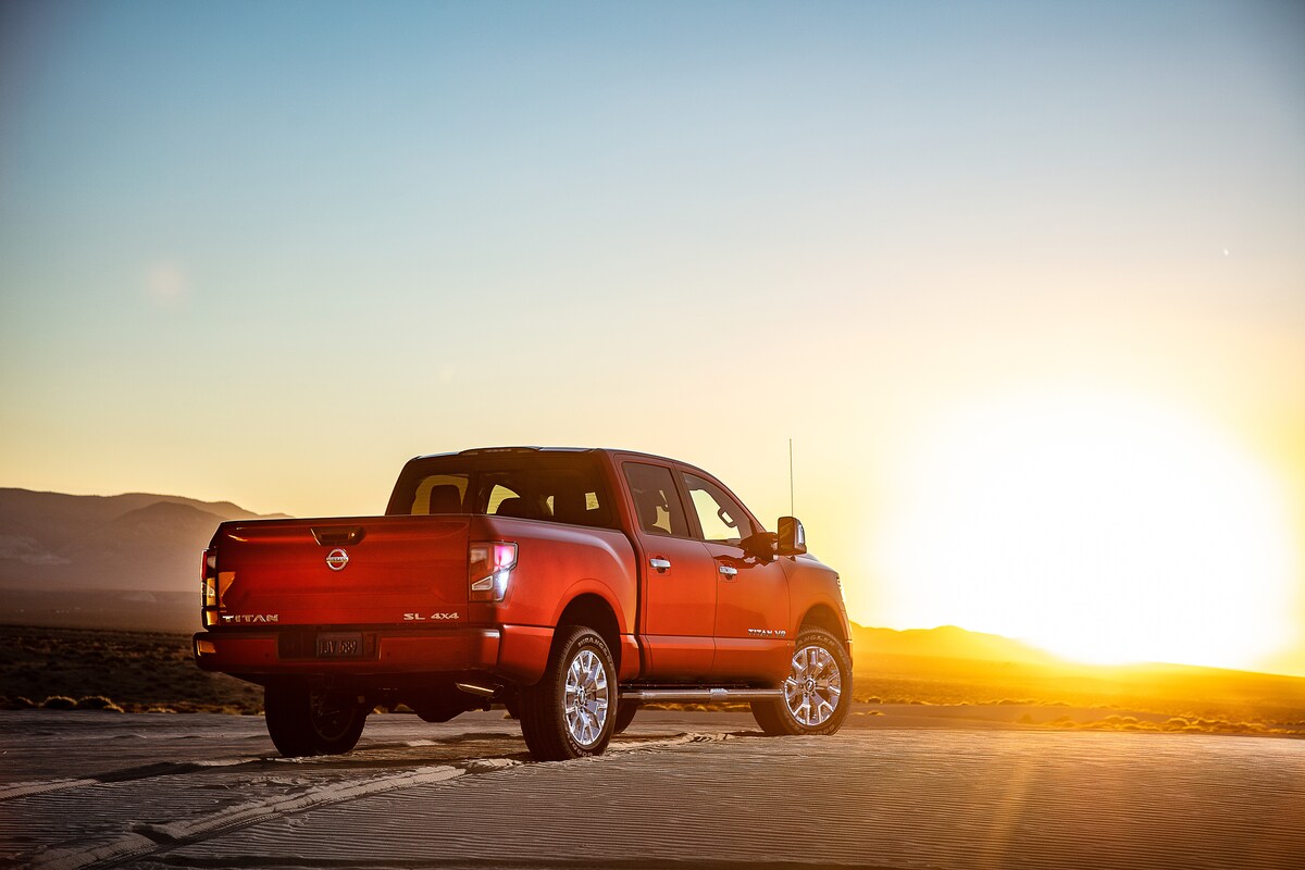 red Nissan Titan SL Crew Cab truck parked on desert sands