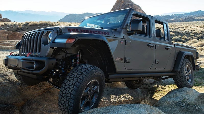 dark grey Jeep Gladiator truck bouldering over rocks at a steep angle