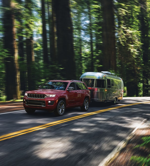 2023-Jeep-GrandCherokee-Overland-SUV.png dark red Jeep Grand Cherokee towing an Airstream