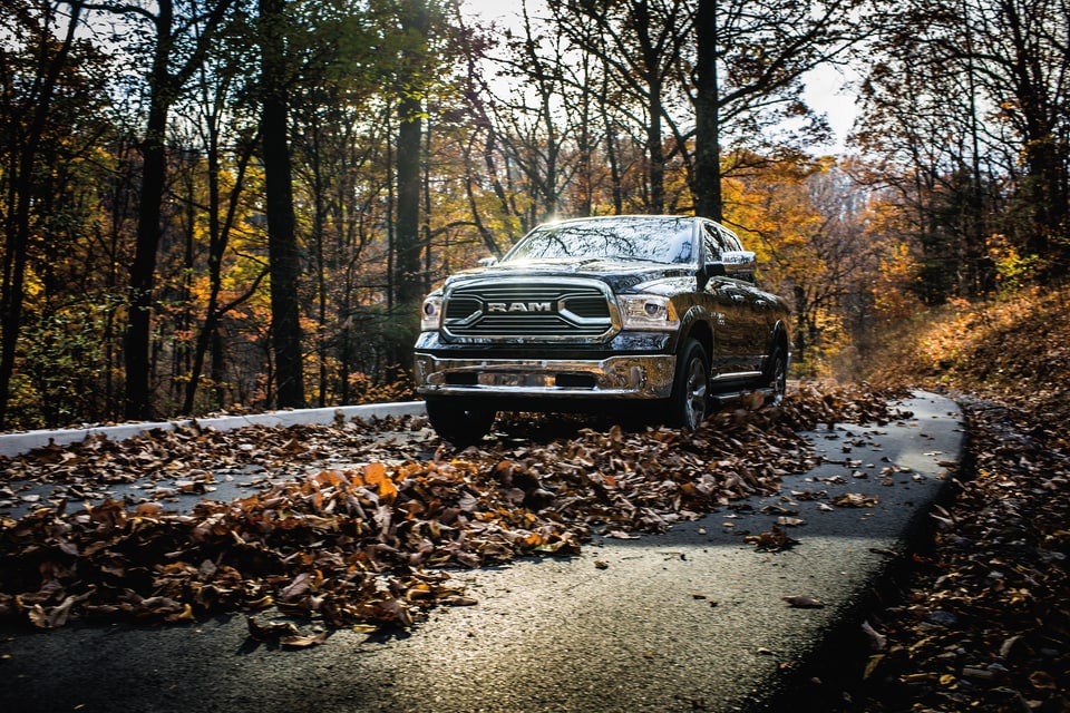 black Ram 1500 driving down a road full of Fall leaves