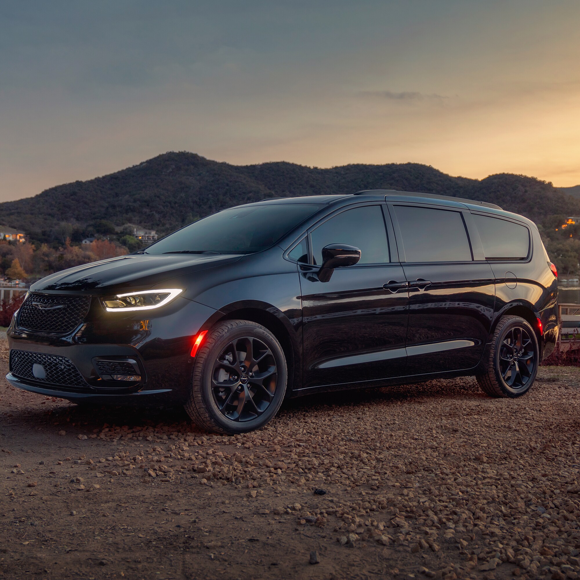 black chrysler pacifica hybrid minivan parked on rocky dirt