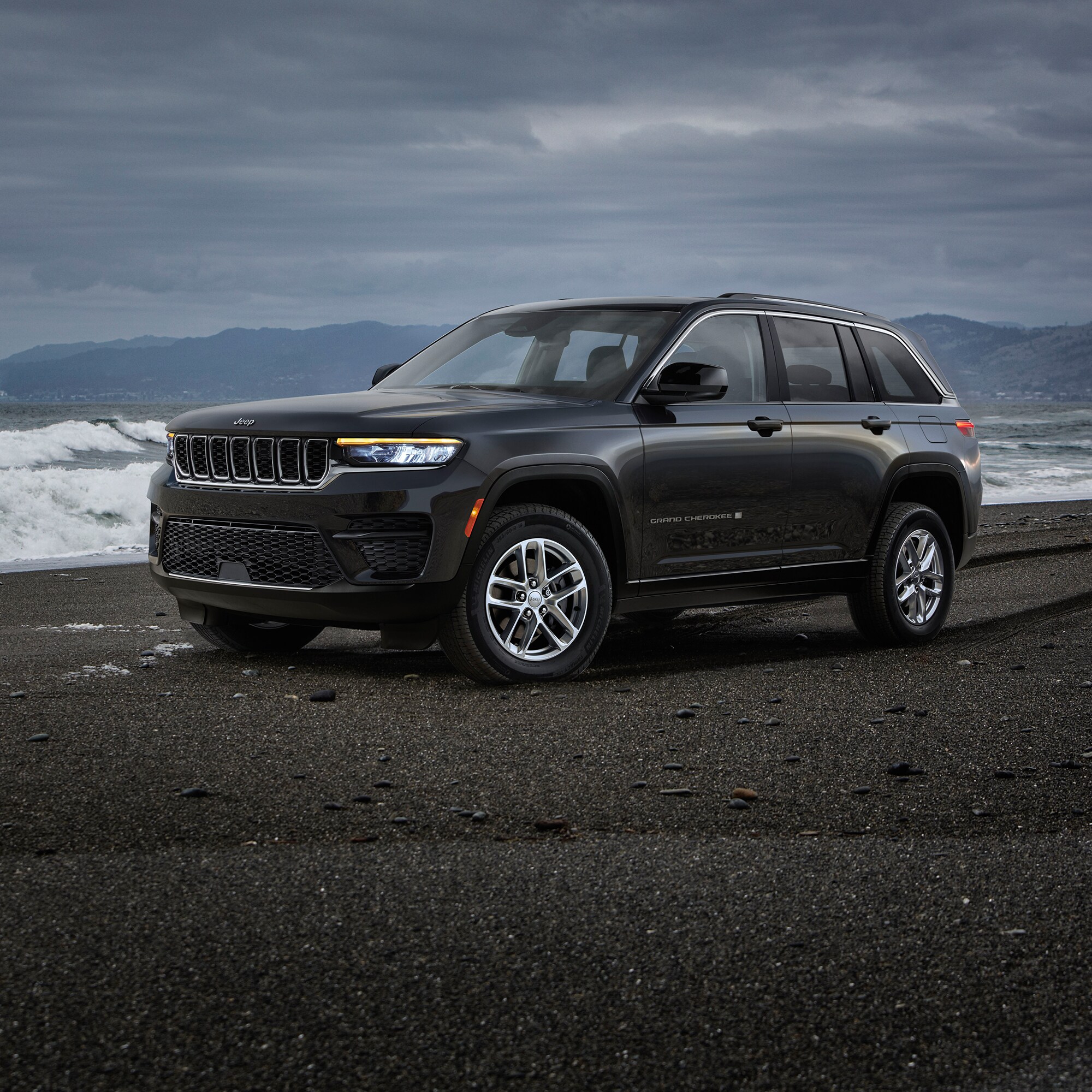 black jeep grand cherokee 4xe hybrid SUV parked on a beach