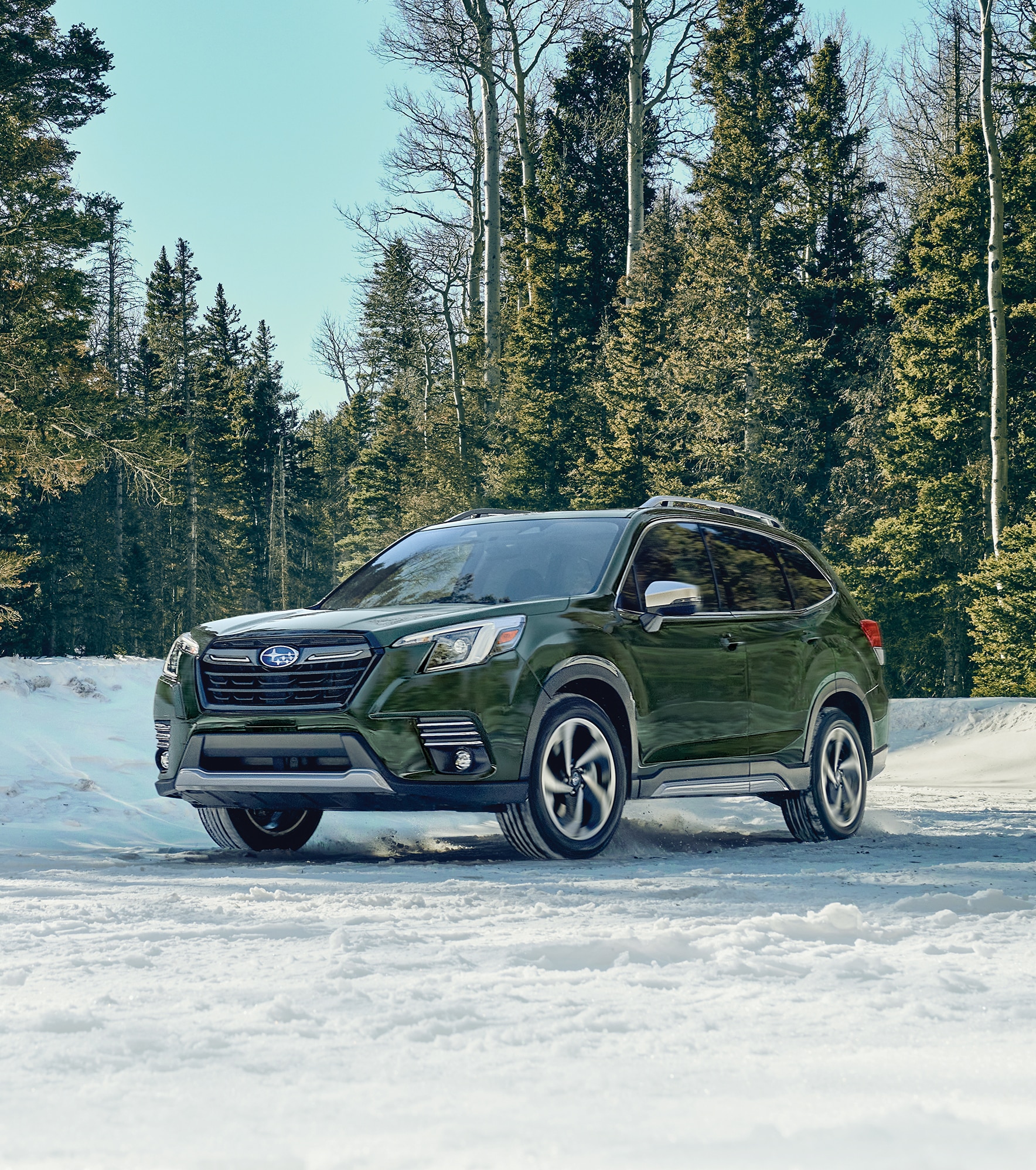 green Subaru parked on the snow