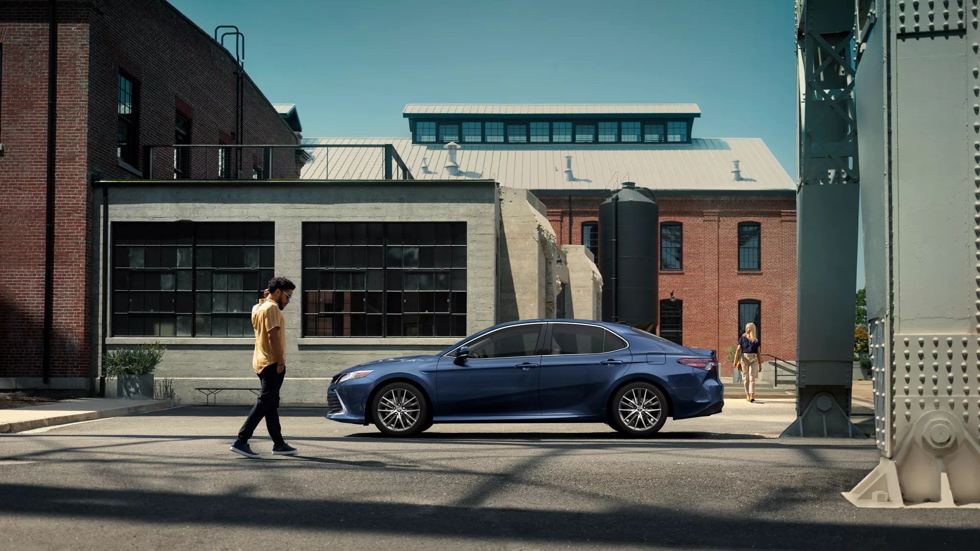 blue Toyota car parked in front of a brick building