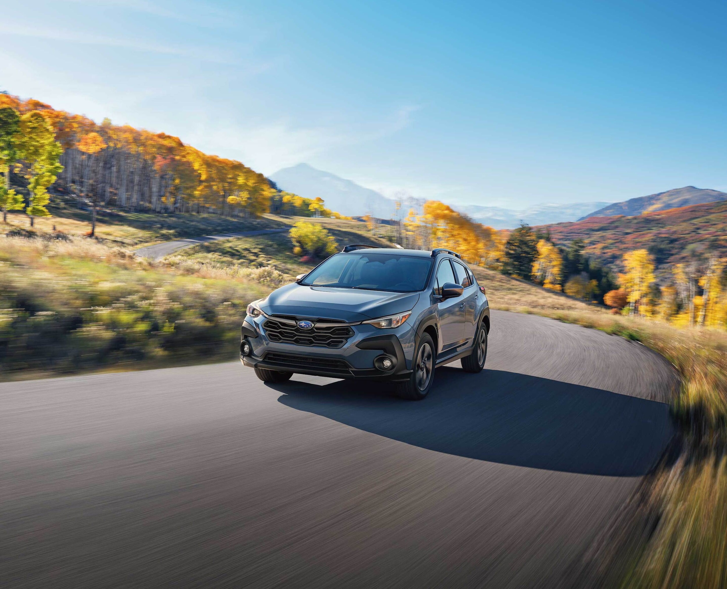 2022-Subaru-Crosstrek-Premium-Hatchback-L04.png Subaru Crosstrek compact SUV driving past a river with bikes attached to the roof-rack