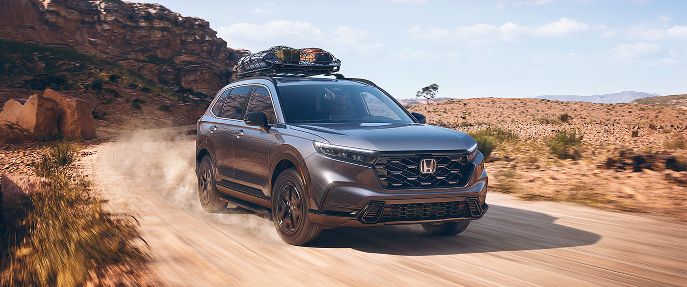 gray Honda SUV driving on a desert road