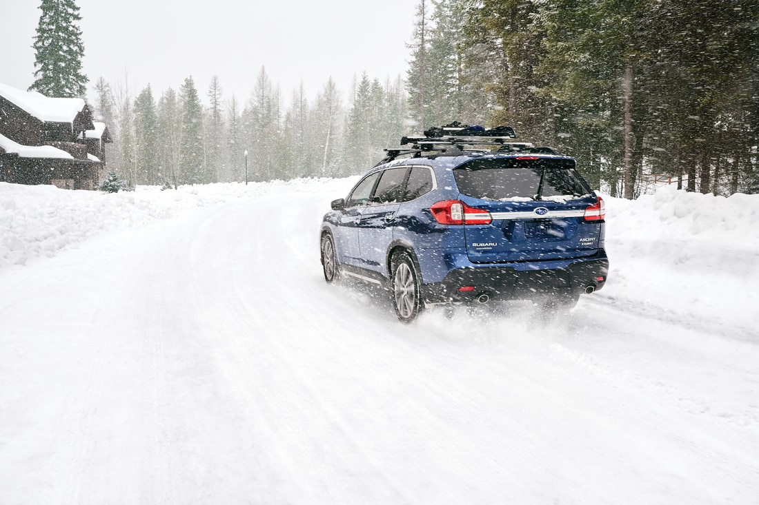blue Subaru Ascent SUV driving through the snow
