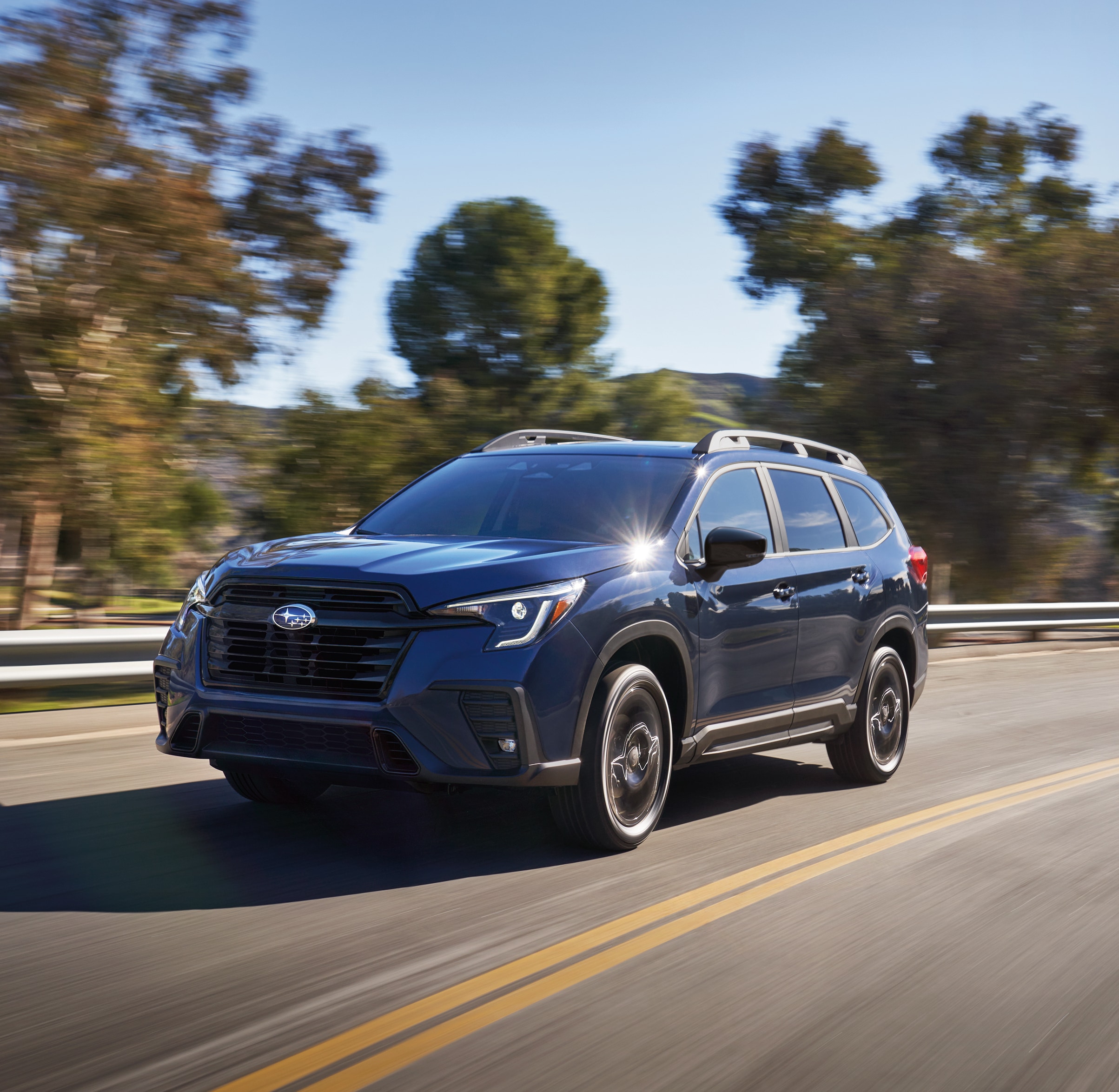 blue Subaru driving on a road