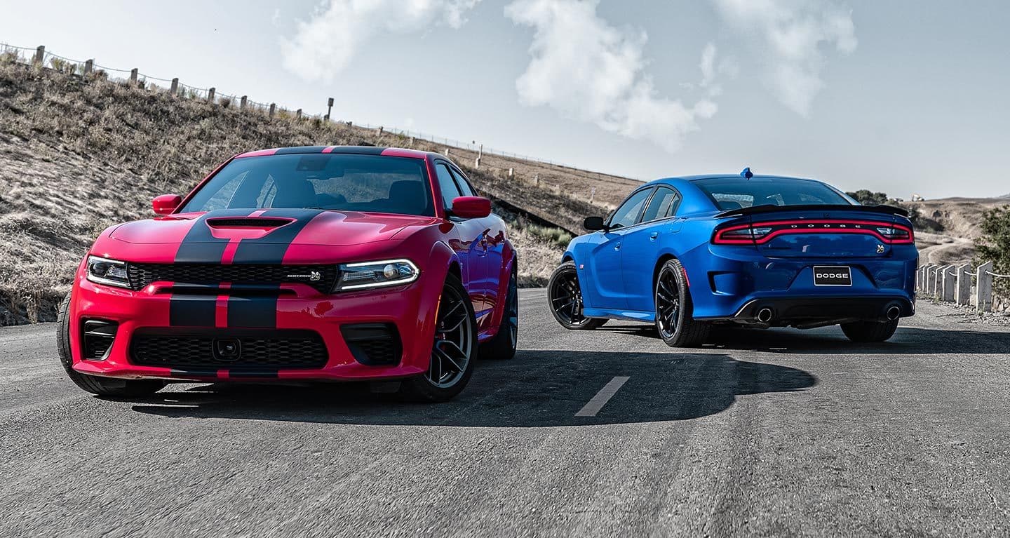 red and blue Dodge Charger cars parked on an arid road