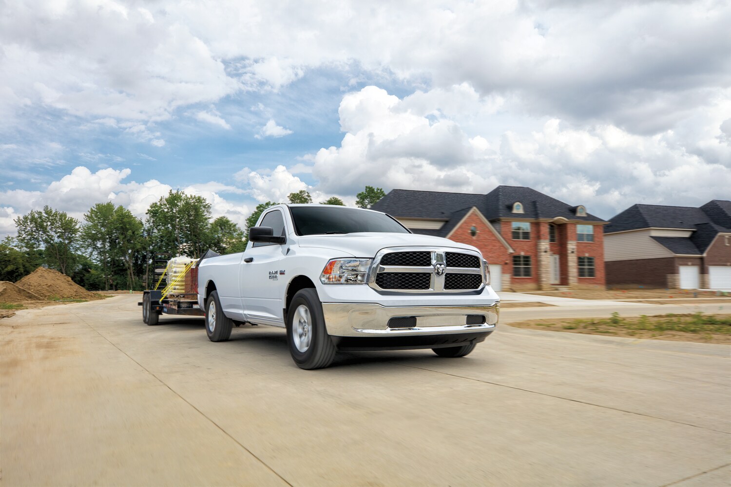 white Ram 1500 Classic Tradesman truck leaving a new home construction site