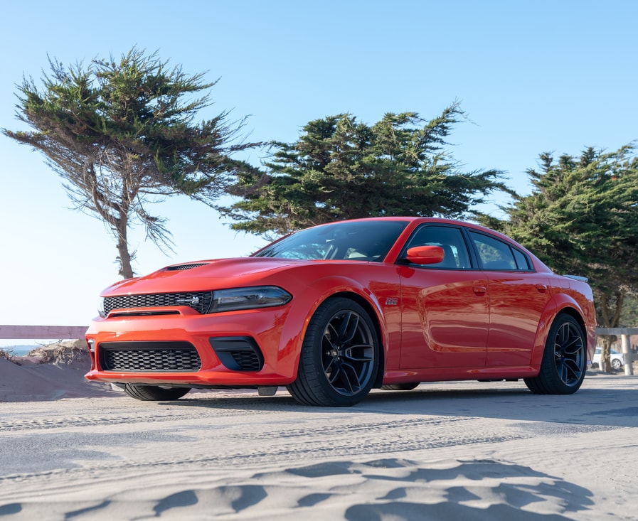 bright red Dodge Charger sports sedan parked in a desert