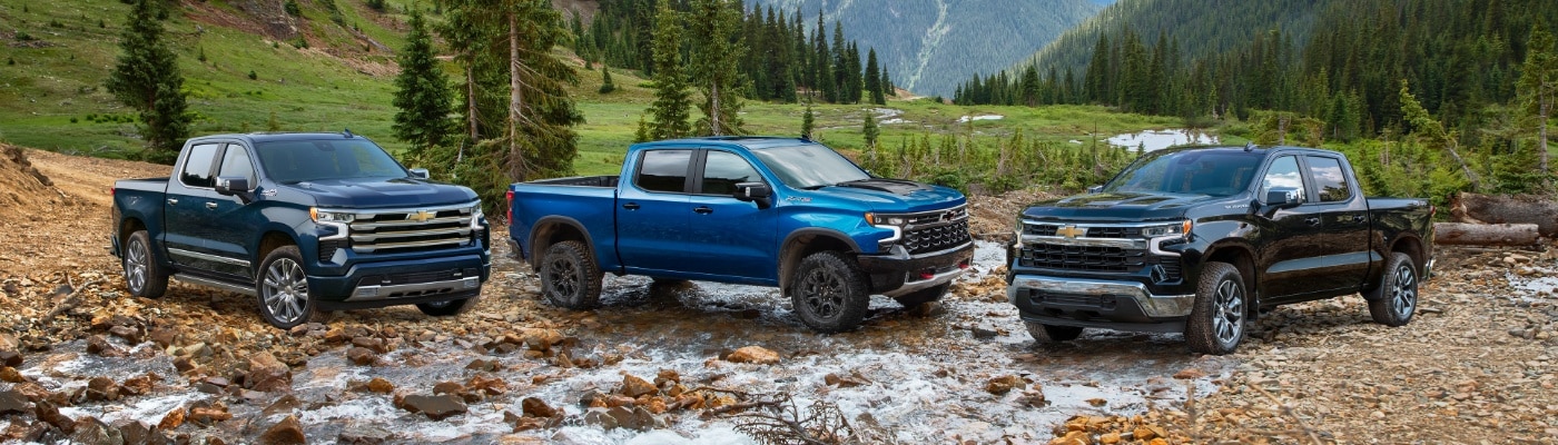 Chevy Silverado Lineup of trucks parked in a rocky creek