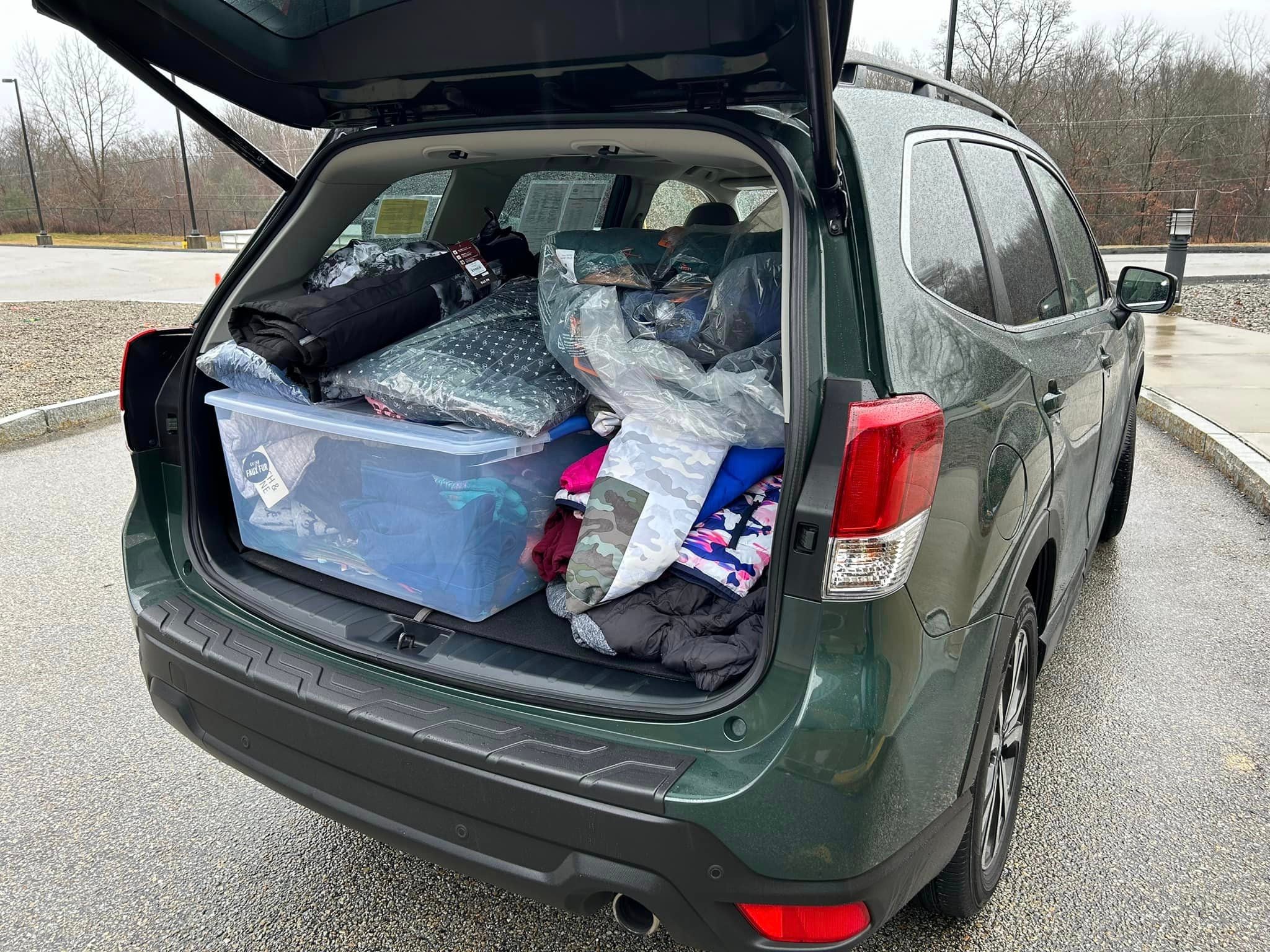 A dark green subaru forester packed full of donations from the community