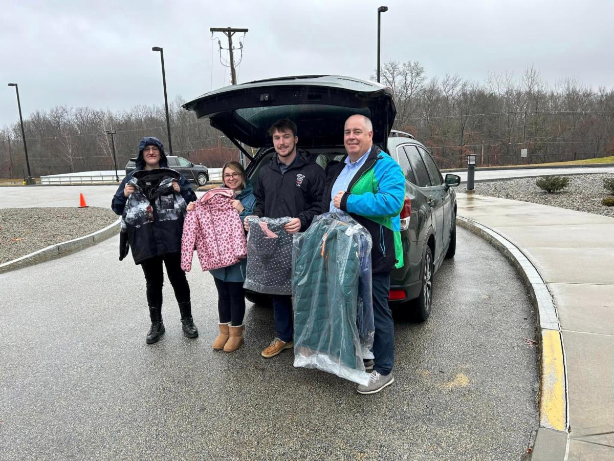 four Long Subaru employees in front of the forester ready to deliver coats to the girls and boys club.