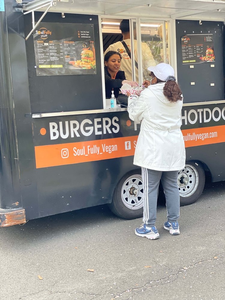 Allison in her food truck serving a customer.