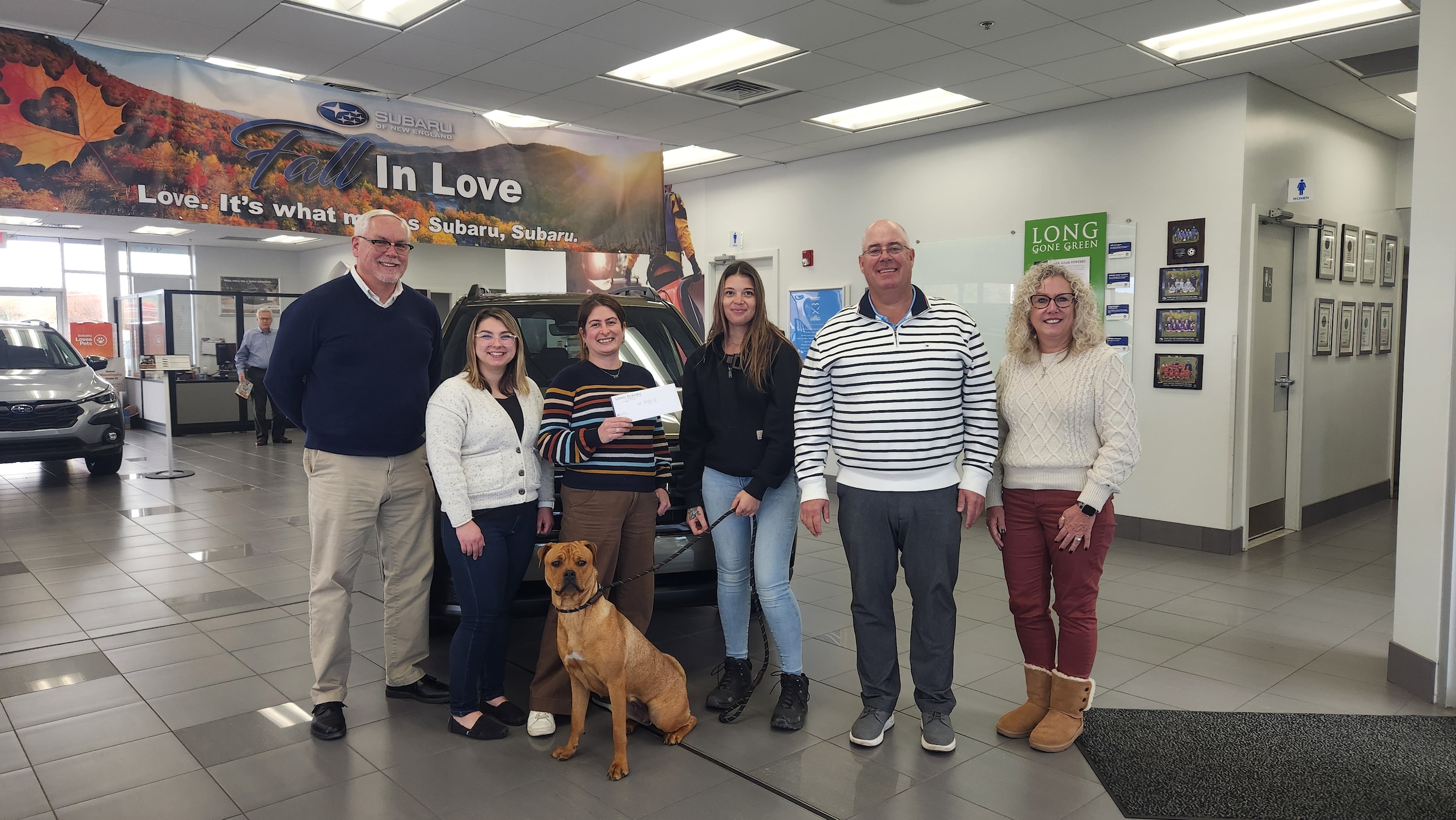 Scott Barry and his staff presenting a check to Animal Control Officer Dessirae Roussin with Ziggy