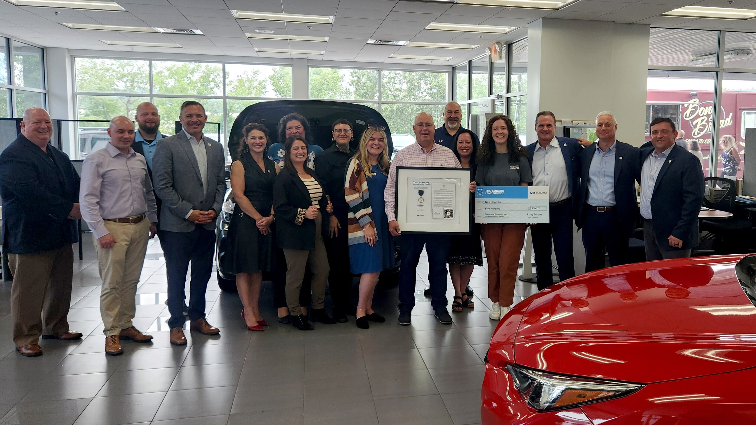 Long Subaru's team holds Love Promise Award. Representatives of Subaru of America and Subaru of New England present the Check to New hope.