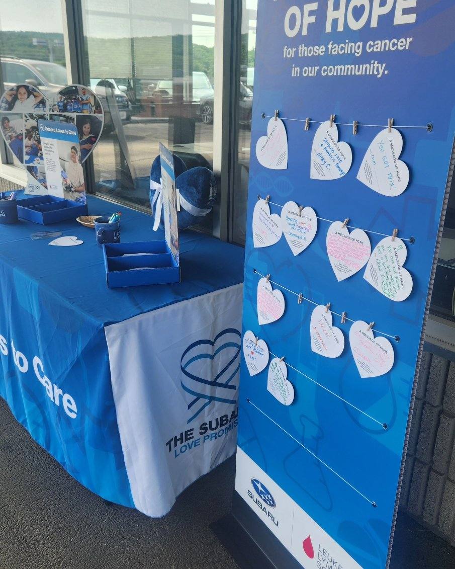 a table with markers and heart shaped cards to write notes on. a display of all the messages