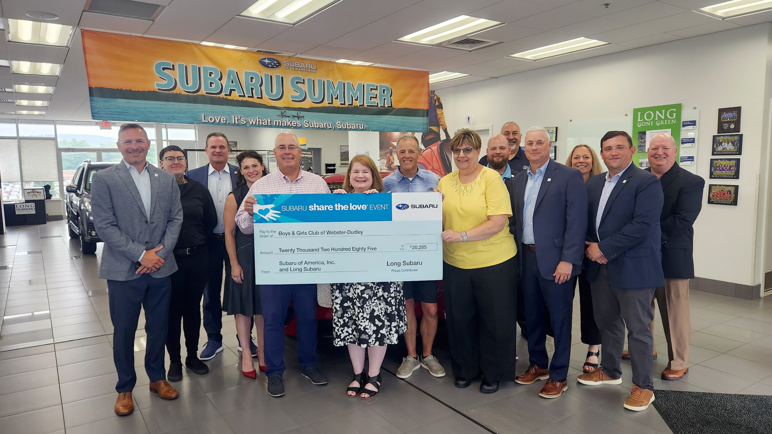 Subaru employees presenting the giant check to the boys and girls club