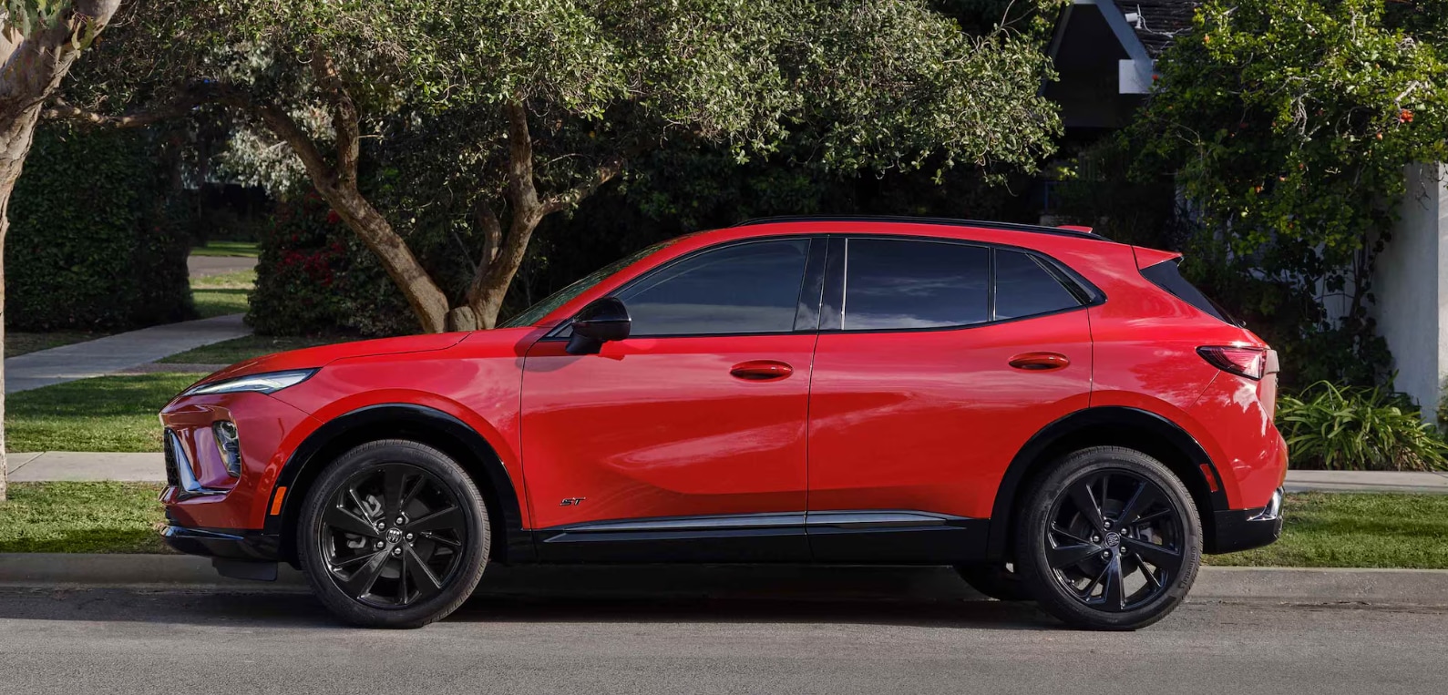 Red 2026 Buick Envision, an outstanding compact SUV, parked outside neighborhood home.