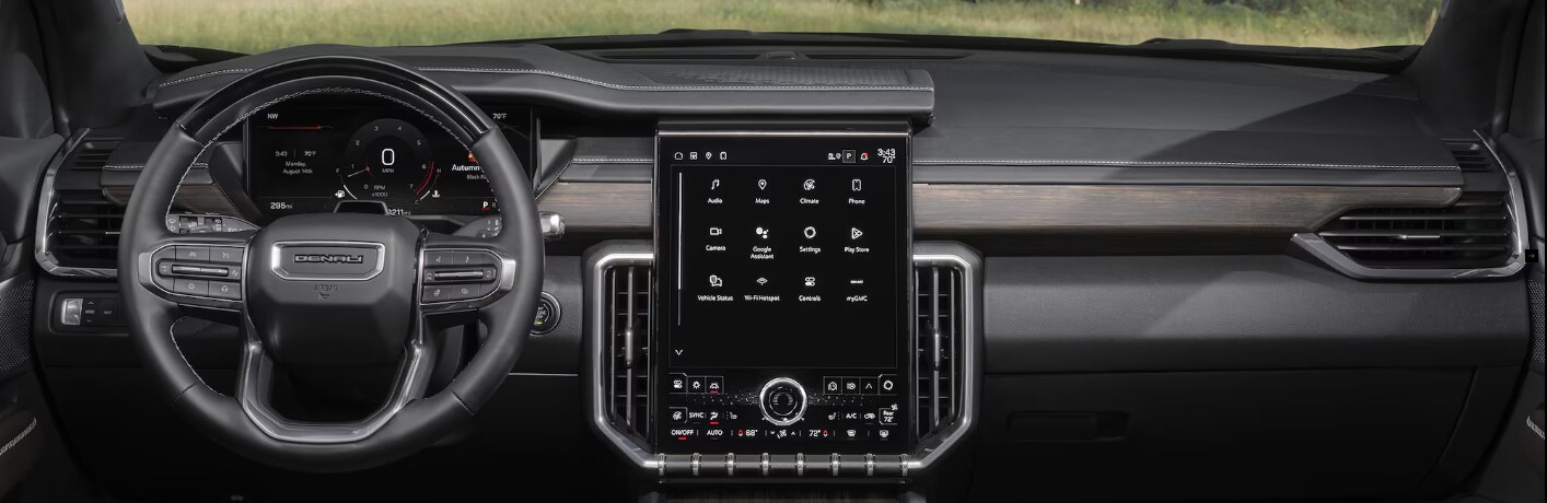 Interior view of a GMC Yukon Denali showcasing its steering wheel and large touchscreen display.