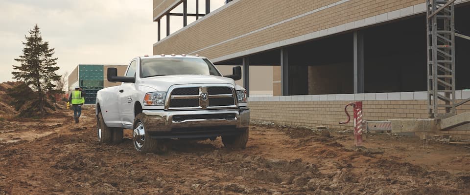 2018 Ram 2500 A white 2018 Ram 2500 parked in the mud next to a building