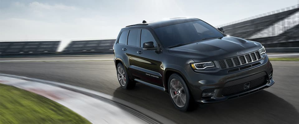 Jeep Grand Cherokee A black Jeep Grand Cherokee driving on an open track