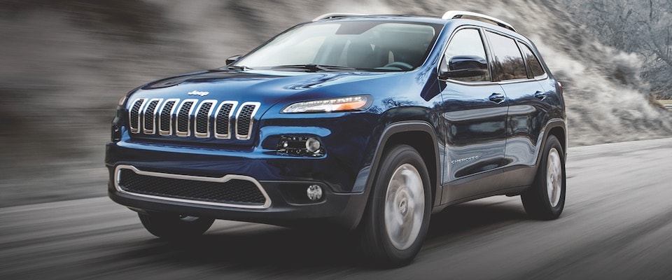 2019 Jeep Cherokee A blue 2019 Jeep Cherokee driving down a road
