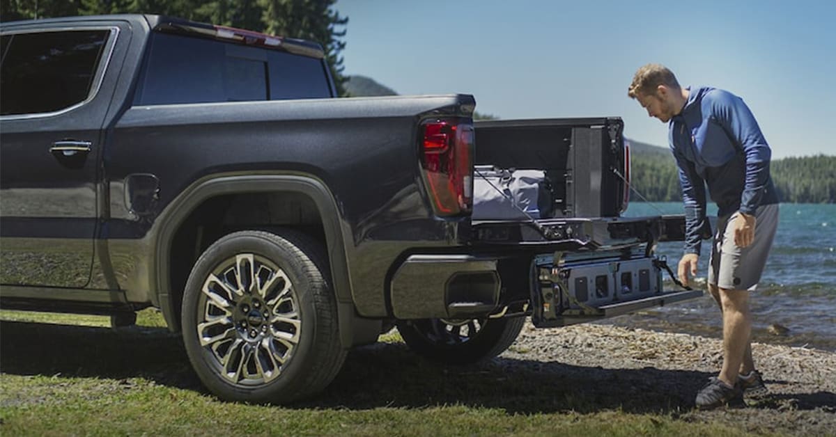 a%20man%20using%20the%20truck%20bed%20of%20the%202025%20GMC%20SIERRA%201500%20.jpg