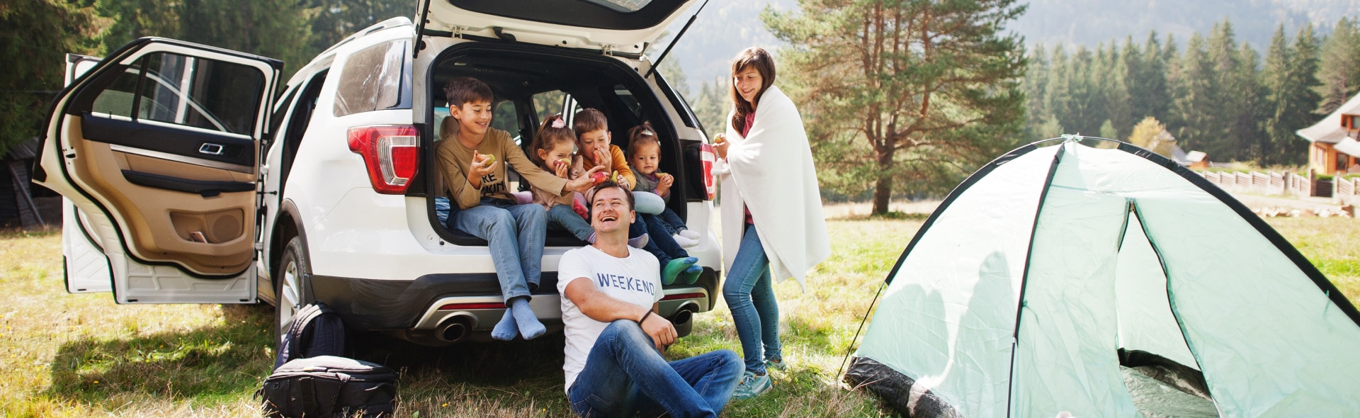 Family camping around SUV