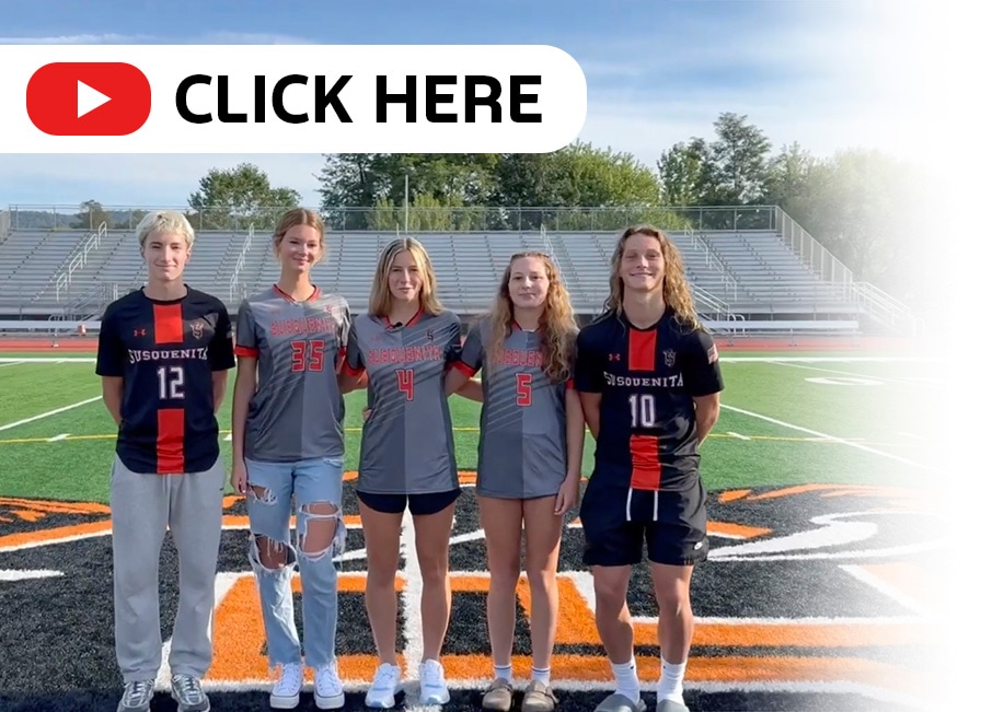 Highschooler standing in front of a football field