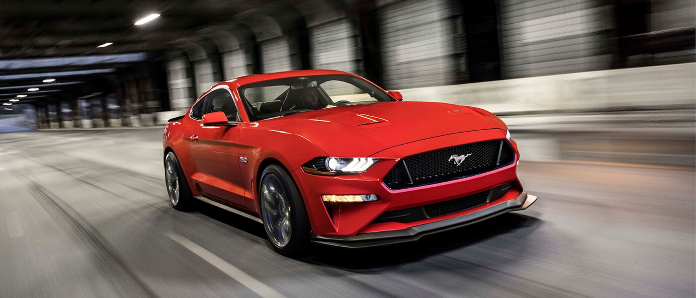 2020 Ford Mustang in red driving in a tunnel.