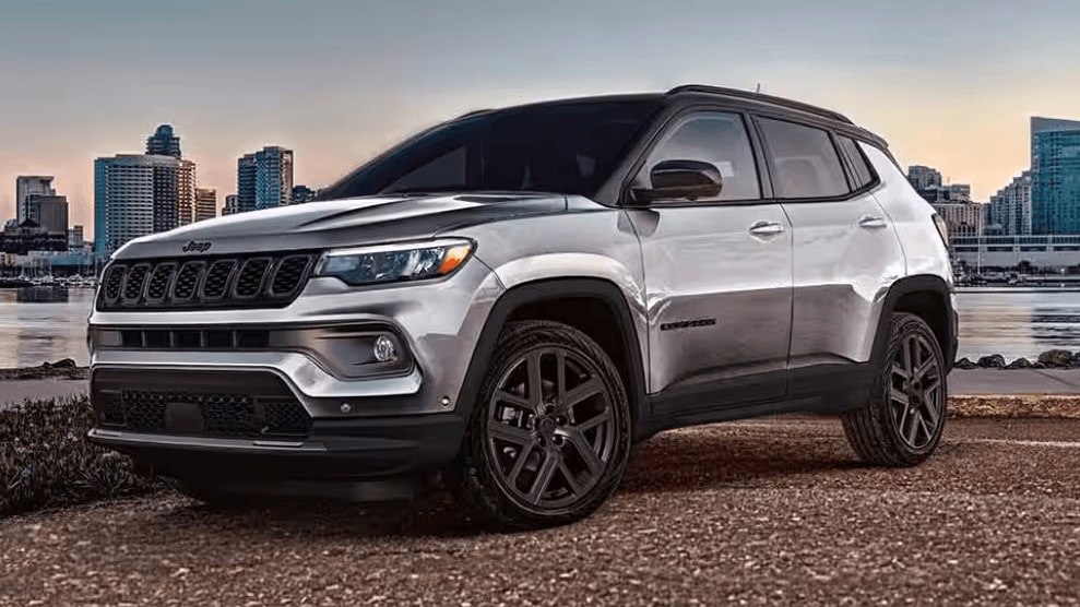 Jeep Compass parked along a waterfront with a city skyline behind it