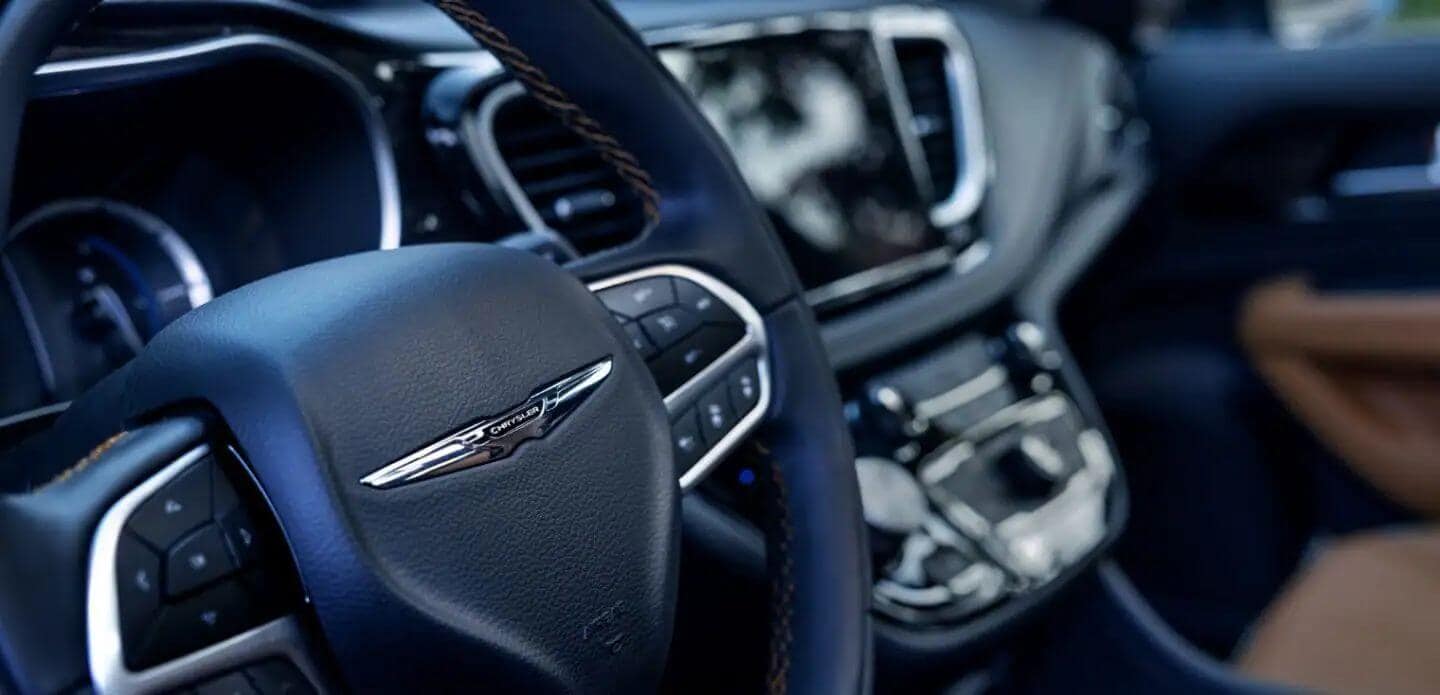 Learn which Chrysler models feature a heated steering wheel, like the Chrysler Pacifica Plug-In Hybrid Interior shot of the Chrysler Pacifica Plug-In Hybrid, showing a close-up of the steering wheel, dashboard, and various controls.