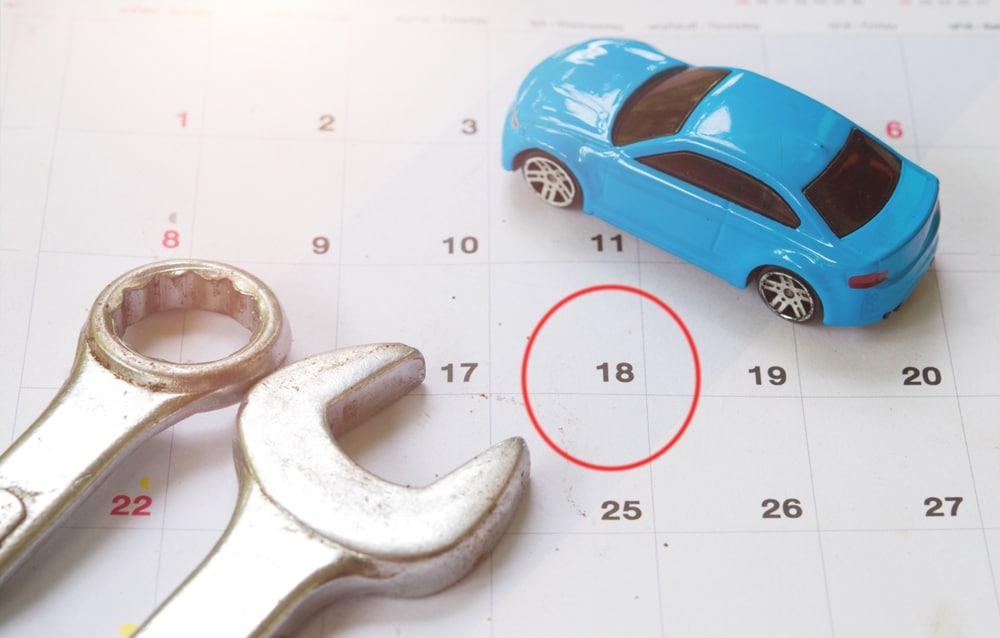 A%20toy%20blue%20car%20and%20two%20wrenches%20on%20a%20calendar%20with%20the%2018th%20circled%20in%20red%2C%20suggesting%20a%20scheduled%20car%20maintenance%20date.jpg