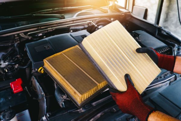 Technician replacing an engine air filter during routine vehicle maintenance