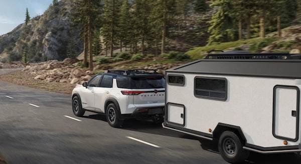 a white 2026 Nissan Pathfinder towing a pop up camper