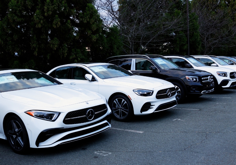 Line up of Mercedes-Benz SUVs and sedans parked in a line in a dealership lot