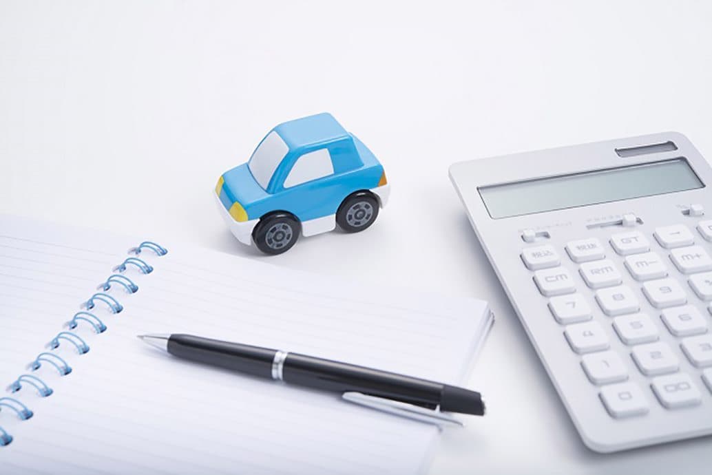 refinancing image with toy car, calculator, and notepad