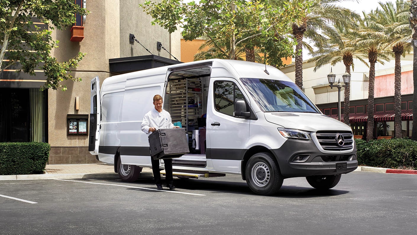 Man unloading catering equipment from a Mercedes-Benz Sprinter Cargo Van