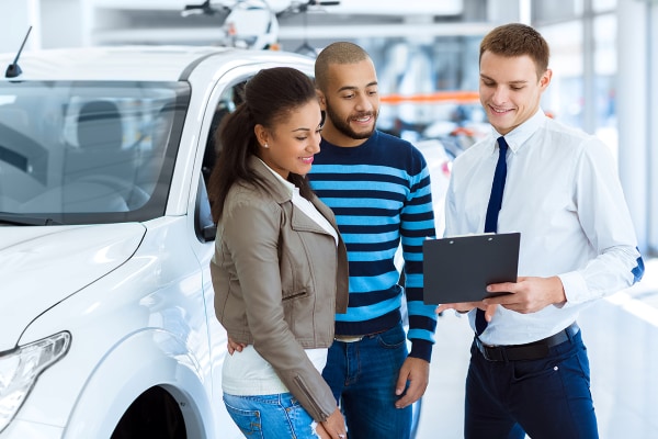 Dealer reviewing financing documents with customers