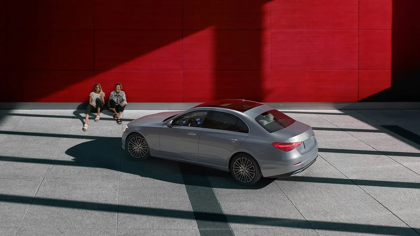 pre-owned Mercedes-Benz C-Class and two people