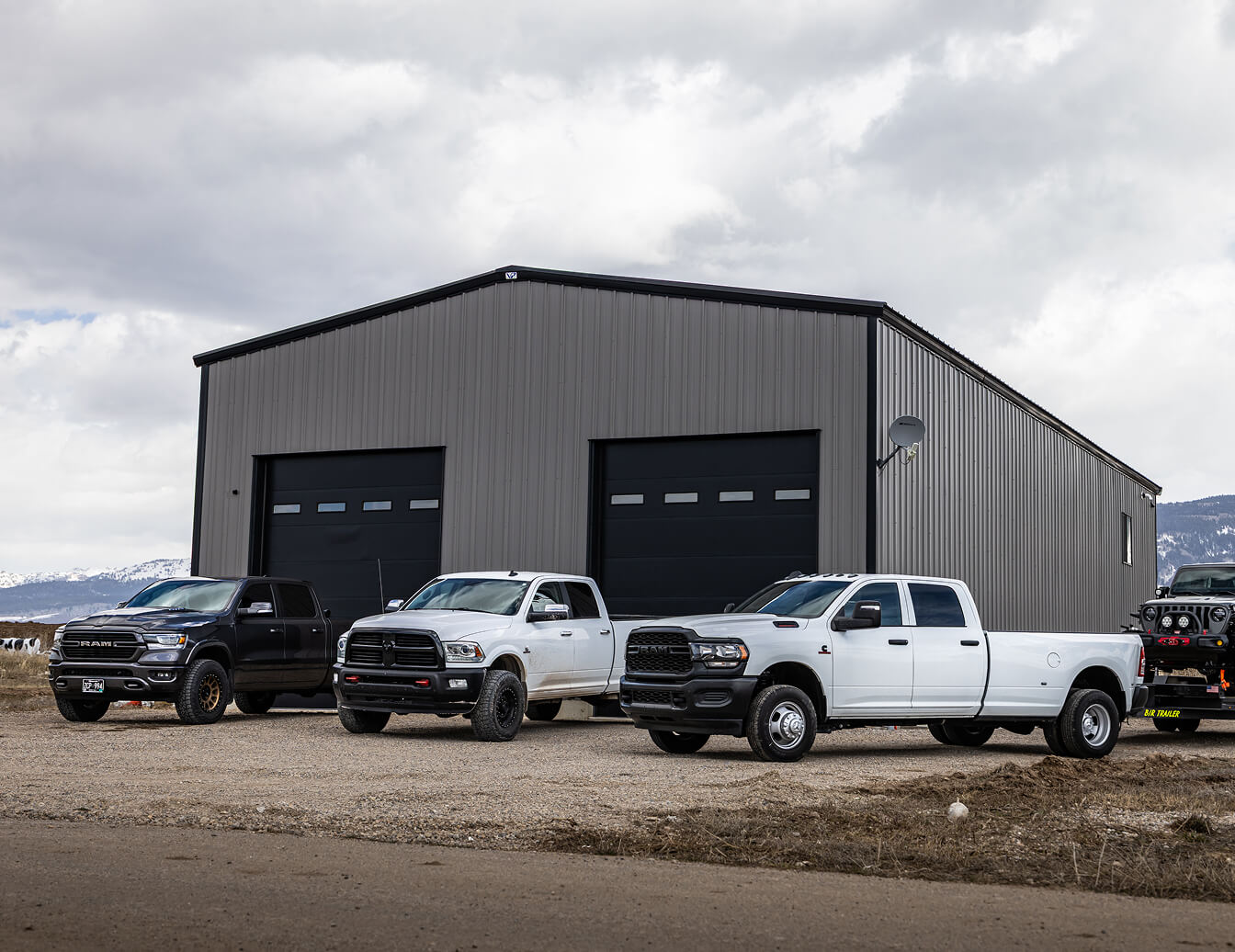 Jeep Lineup featuring a 2024 Jeep Wagoneer, 2025 Jeep Grand Wagoneer Series III Obsidian, and a 2025 Jeep Wagoneer S parked on dirt surrounded by mountains
